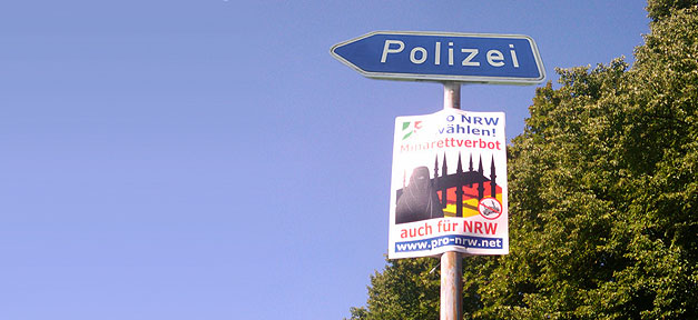 Hoher Pro-NRW-Funktionär und Polizeihauptkommissar weiter im Dienst Die Polizei und ein Wahlplakat der rechtsextremen Pro NRW © Wam Kat © flickr.com (CC 2.0), bearb. MiG