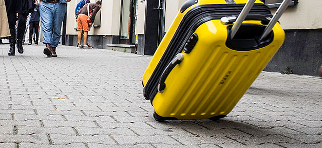 Zehn Prozent der Weltbevölkerung wollen auswandern koffer, trolley, reisekoffer, rollkoffer, straße, passanten